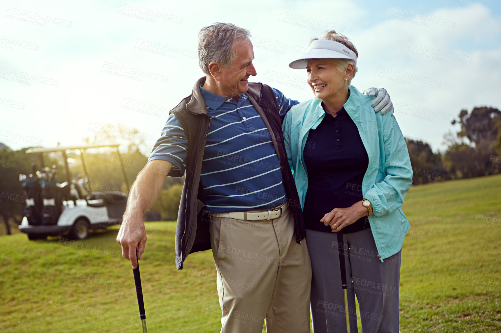 Buy stock photo Golf, hug and retirement with senior couple outdoor on course together for leisure activity. Grass, hobby or smile with old people embracing and playing sports for bonding or recreation in summer