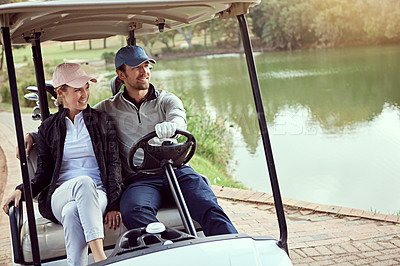 Buy stock photo Shot of a smiling young couple riding in a cart on a golf course