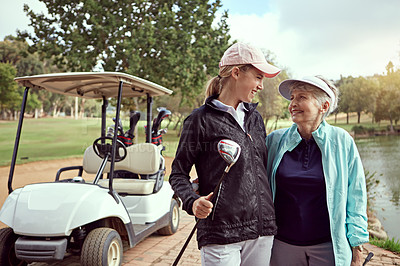 Buy stock photo Shot of a senior woman and her adult daughter enjoying a day on the golf course