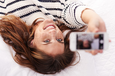 Buy stock photo Cropped shot of a beautiful young woman taking a selfie at home