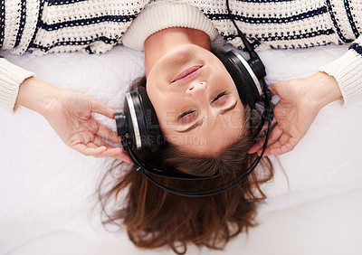 Buy stock photo Cropped shot of a beautiful young woman listening to music at home