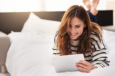 Buy stock photo Shot of a beautiful young woman using a digital tablet at home