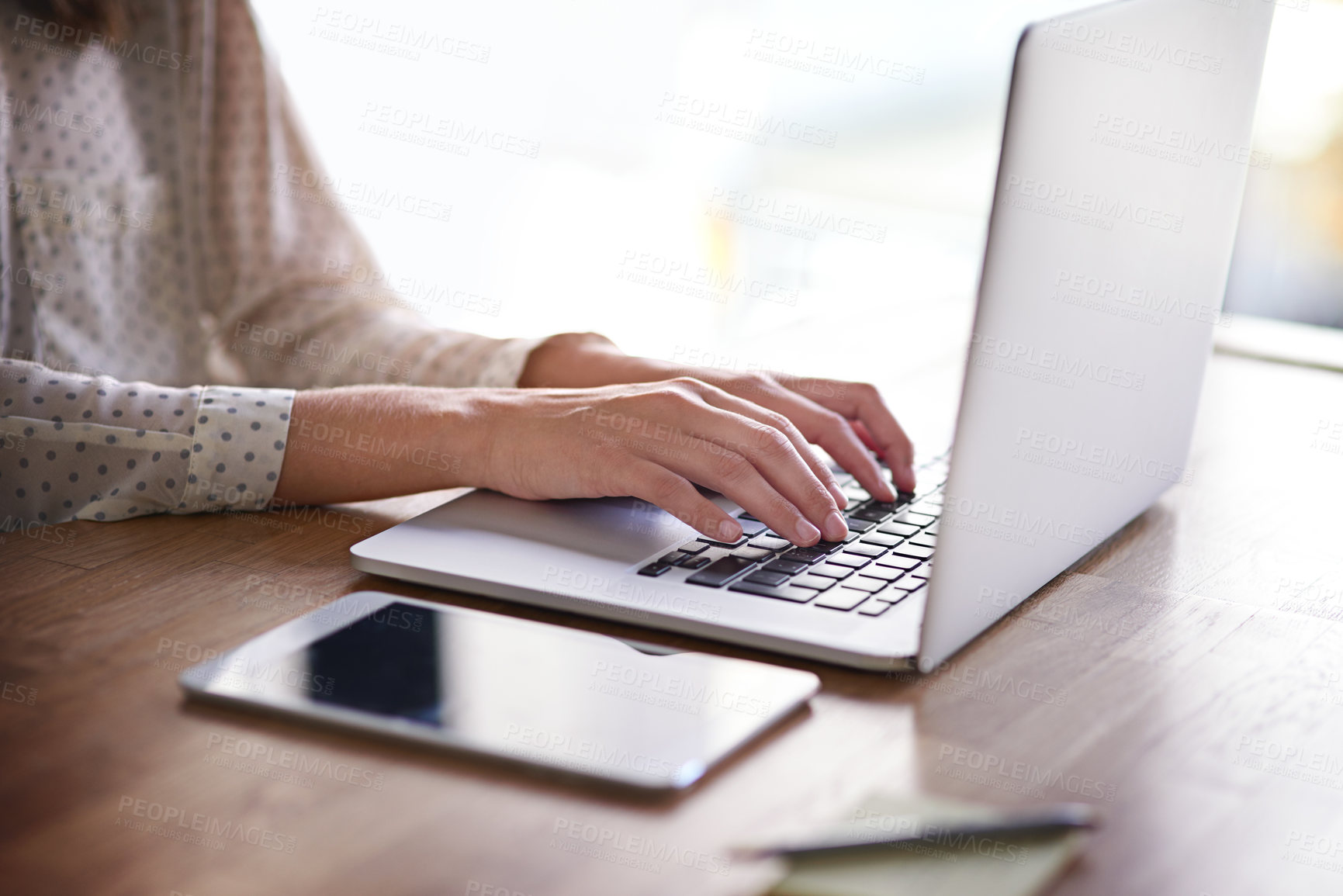 Buy stock photo Cropped shot of a young businesswoman working on a laptop in an office