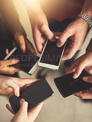 Buy stock photo Shot of a group of colleagues using their cellphones in an office