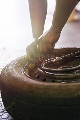 Buy stock photo Tyre, hands and wheel in garage for repairs, rubber and fixing or replace fitting on car at shop. Closeup, person and service or safety check or inspection, motor and alignment of vehicle to change