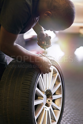 Buy stock photo Cropped shot of a mechanic repairing a car tyre