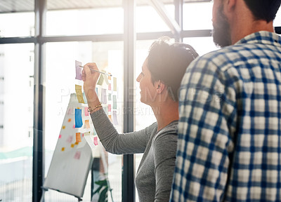 Buy stock photo Glass, planning and writing with designer business people in office together for coaching or development. Collaboration, sticky notes and training with employee team brainstorming in design workplace