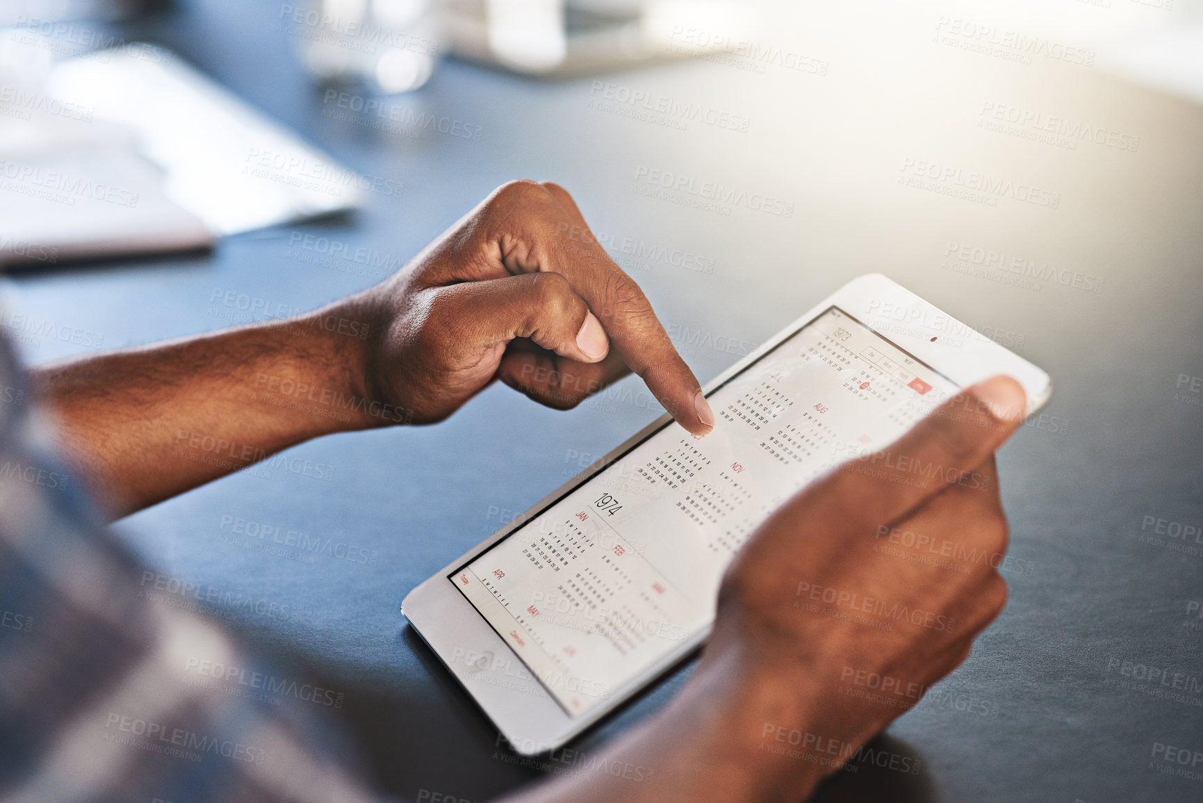 Buy stock photo Cropped shot of a young businessman using a digital tablet in an office