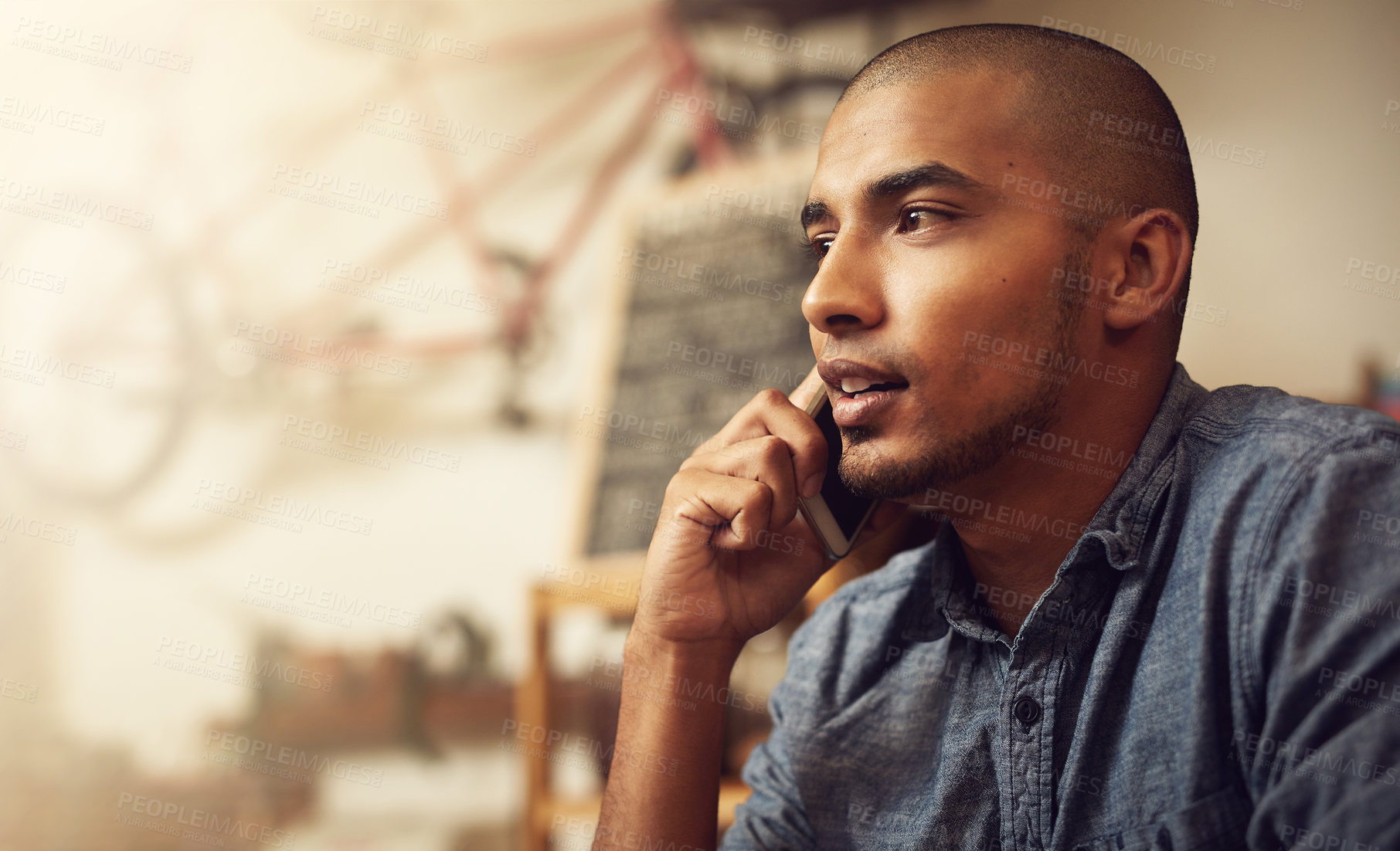 Buy stock photo Shot of a young entrepreneur using a phone in his store