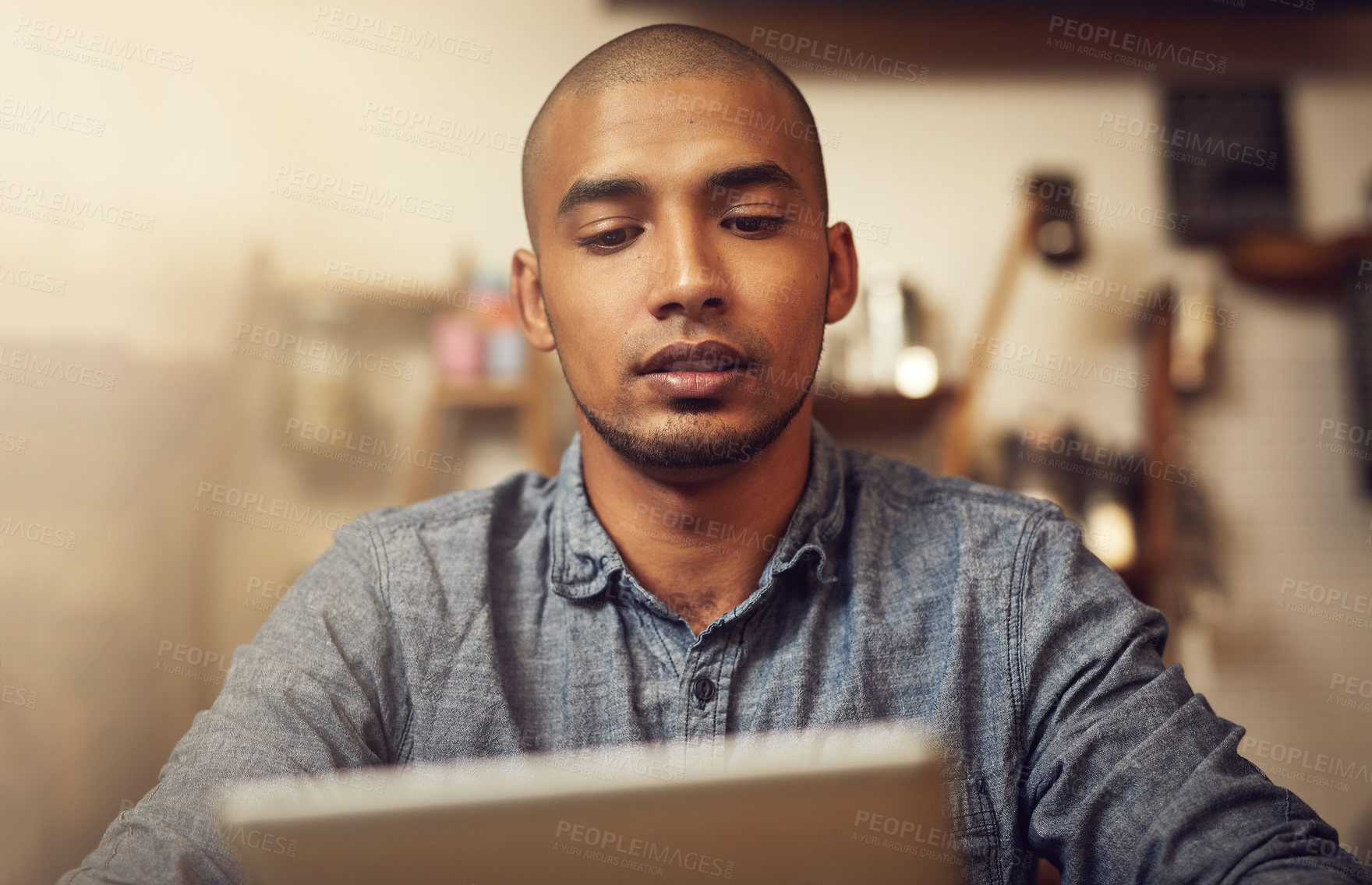 Buy stock photo Shot of a young entrepreneur using a digital tablet in his store