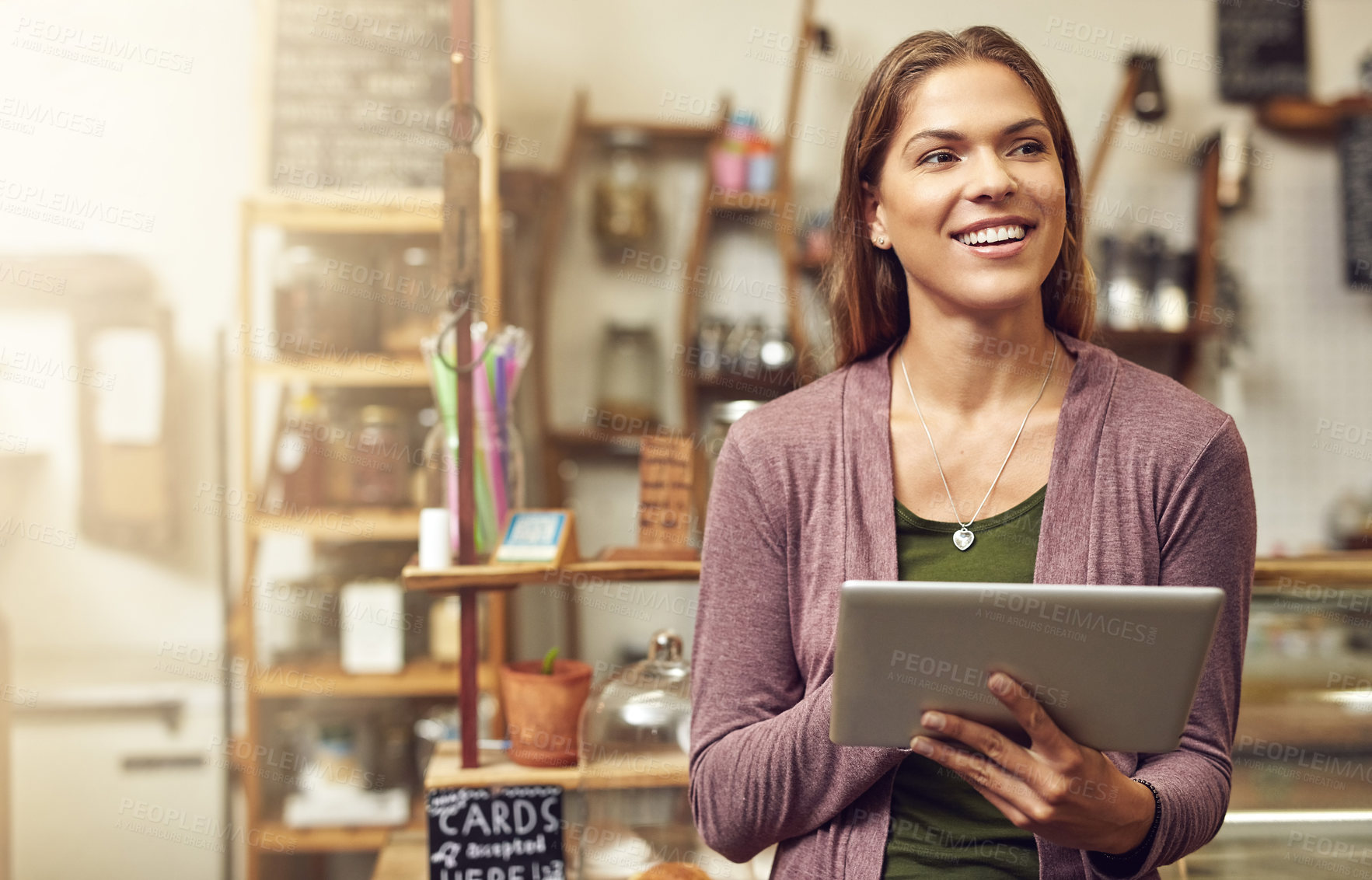 Buy stock photo Shot of a young entrepreneur using a digital tablet in her store