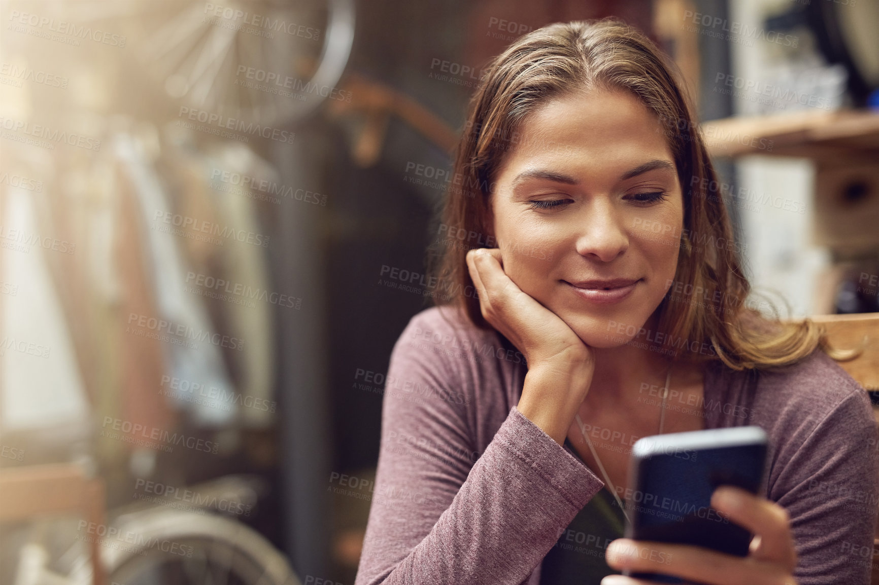 Buy stock photo Shot of a young woman using her phone in a cafe