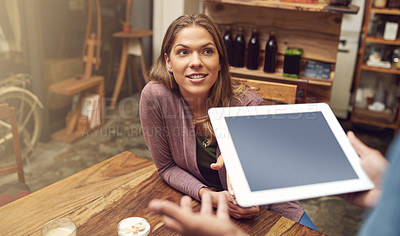 Buy stock photo Shot of a young woman placing her order with a waiter using a digital tablet