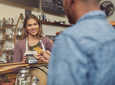Buy stock photo Shot of a store assistant taking a credit card payment from her customer