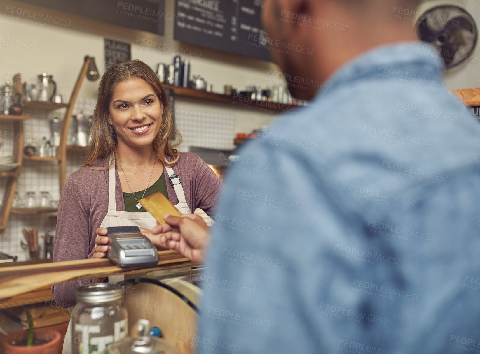 Buy stock photo Shot of a store assistant taking a credit card payment from her customer