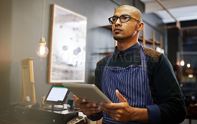 Buy stock photo Cropped shot of a young entrepreneur using a digital tablet in his business