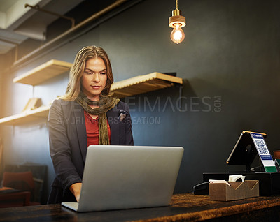 Buy stock photo Cropped shot of a young business owner using a laptop in her shop