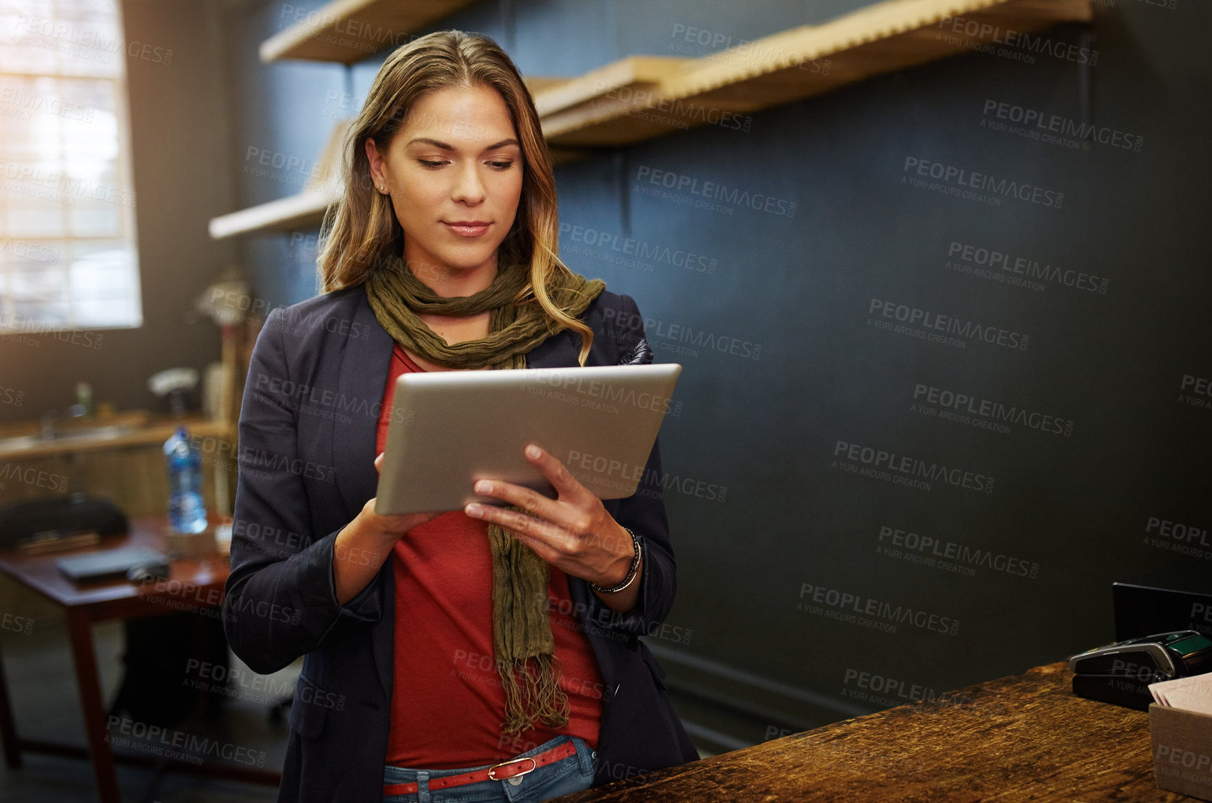 Buy stock photo Cropped shot of a young business owner using a digital tablet in her shop