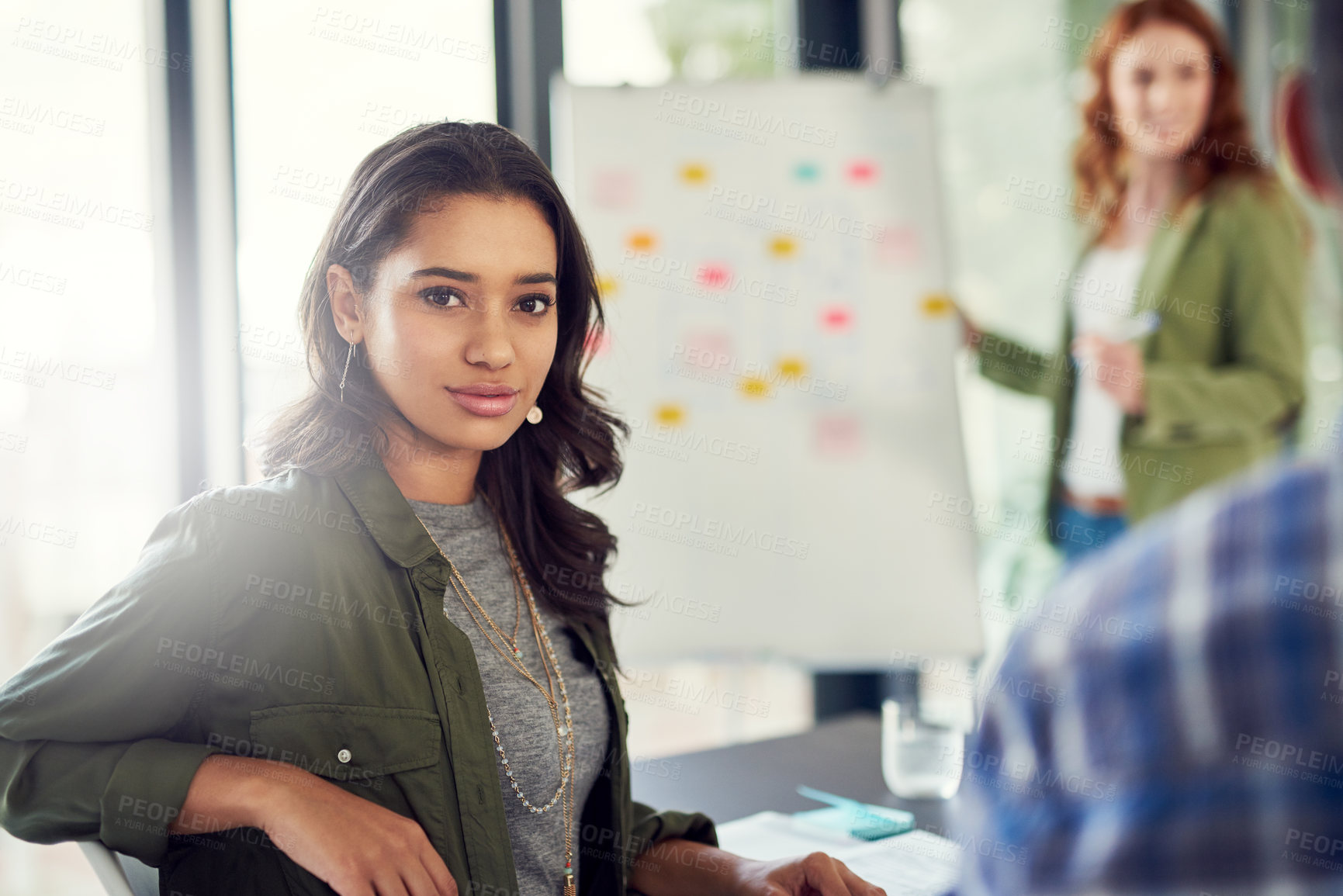 Buy stock photo Portrait of a young businesswoman sitting in a modern office with her colleagues