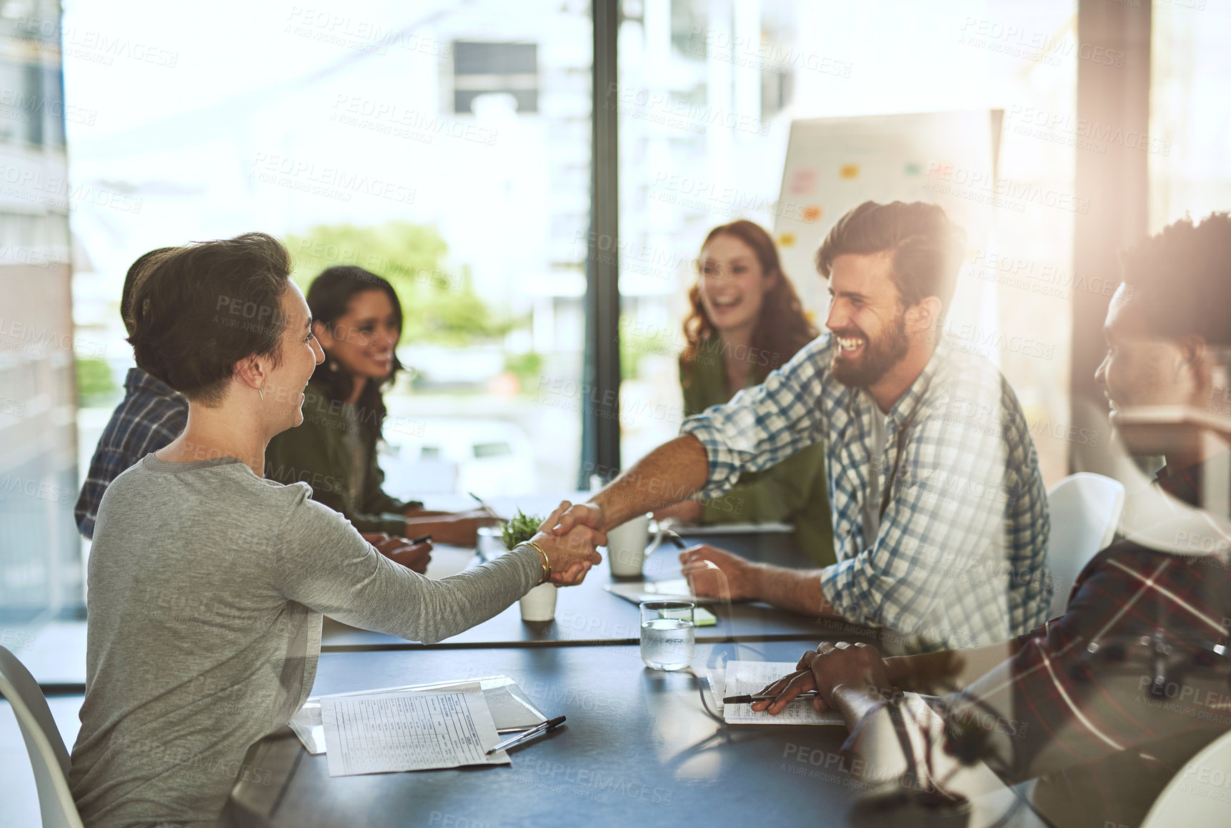 Buy stock photo Cropped shot of businesspeople shaking hands in a modern office