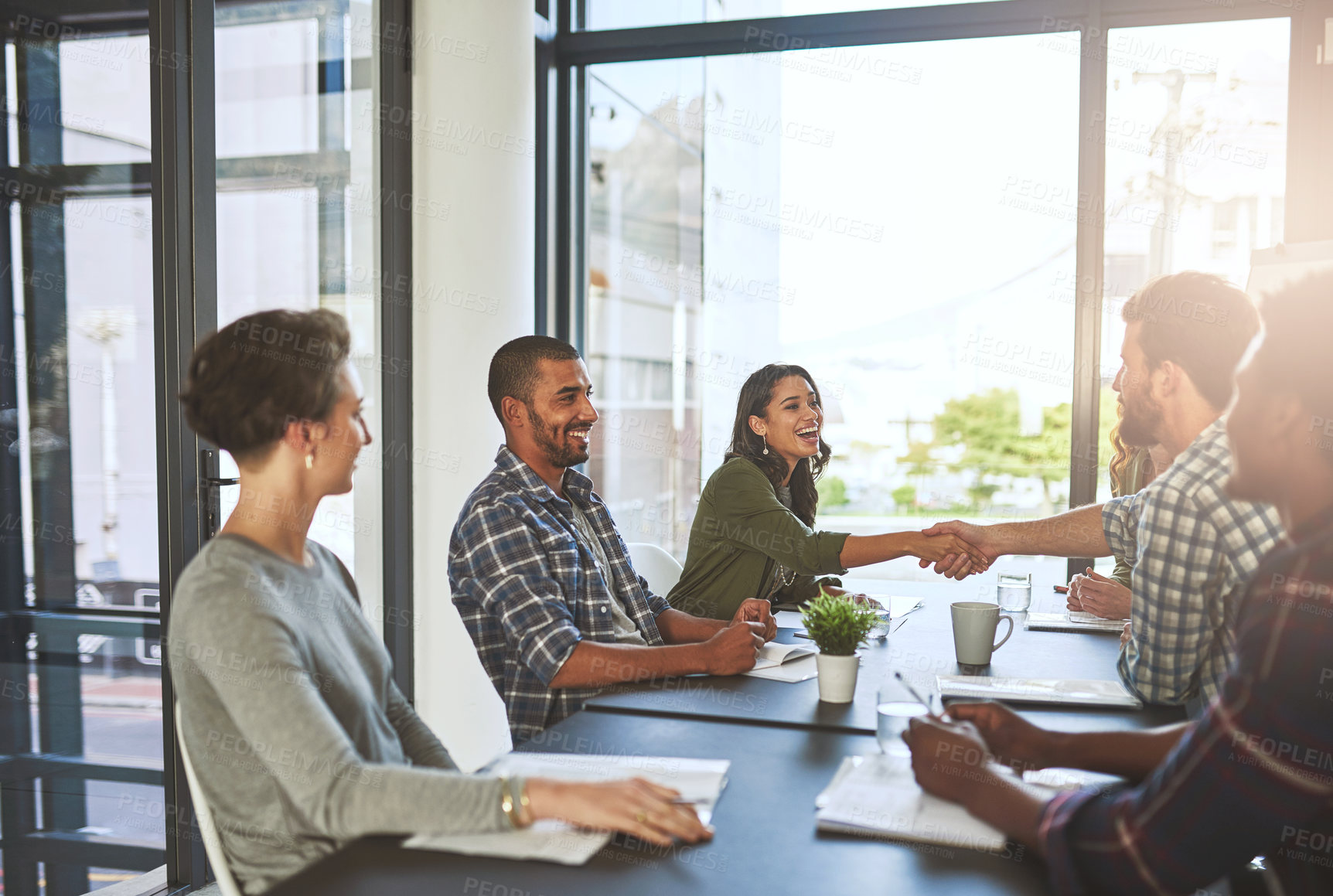 Buy stock photo Cropped shot of businesspeople shaking hands in a modern office