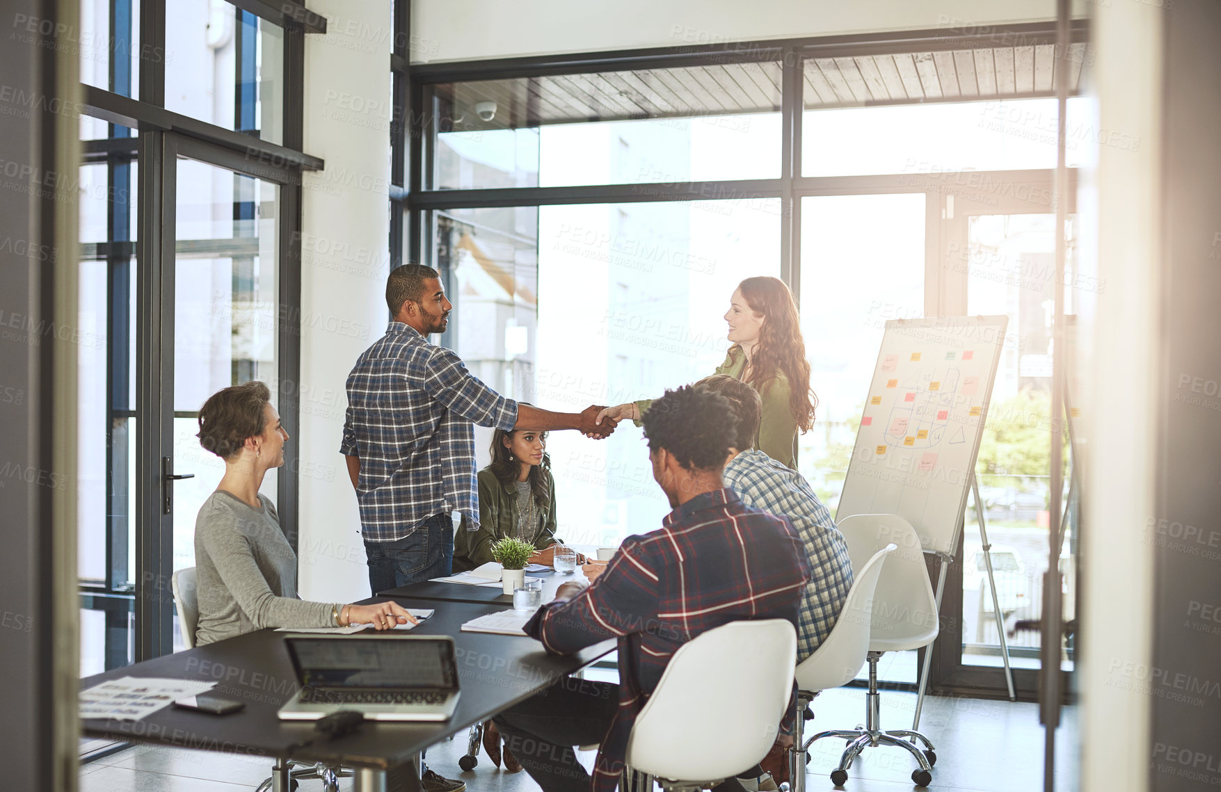 Buy stock photo Cropped shot of businesspeople shaking hands in a modern office