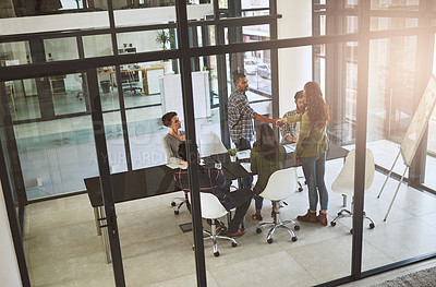 Buy stock photo Shot of businesspeople shaking hands in a modern office