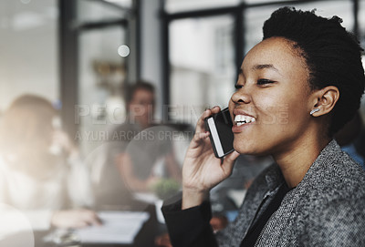Buy stock photo Cropped shot of a young businesswoman talking on a phone with colleagues sitting in the background