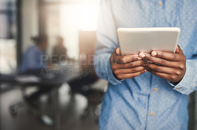 Buy stock photo Closeup shot of a young businessman using a digital tablet in an office