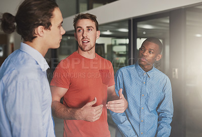 Buy stock photo Shot of three colleagues having a discussion in an office