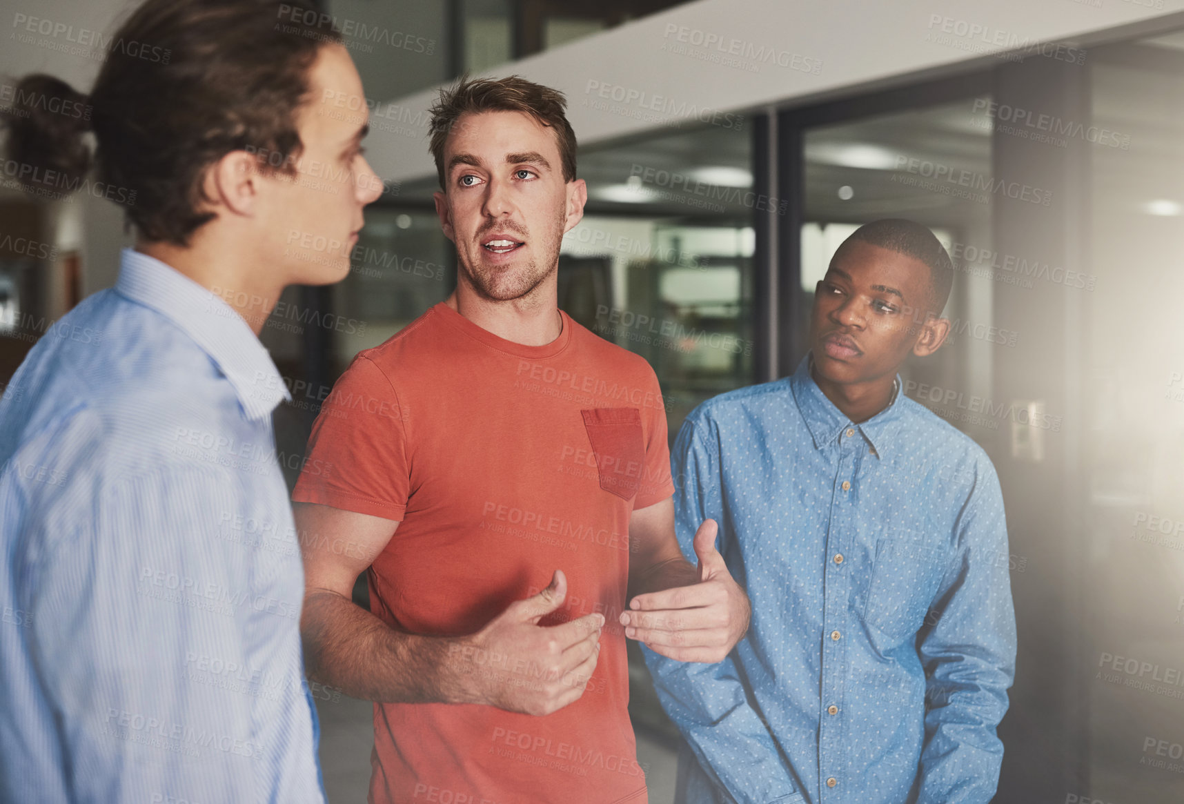 Buy stock photo Shot of three colleagues having a discussion in an office