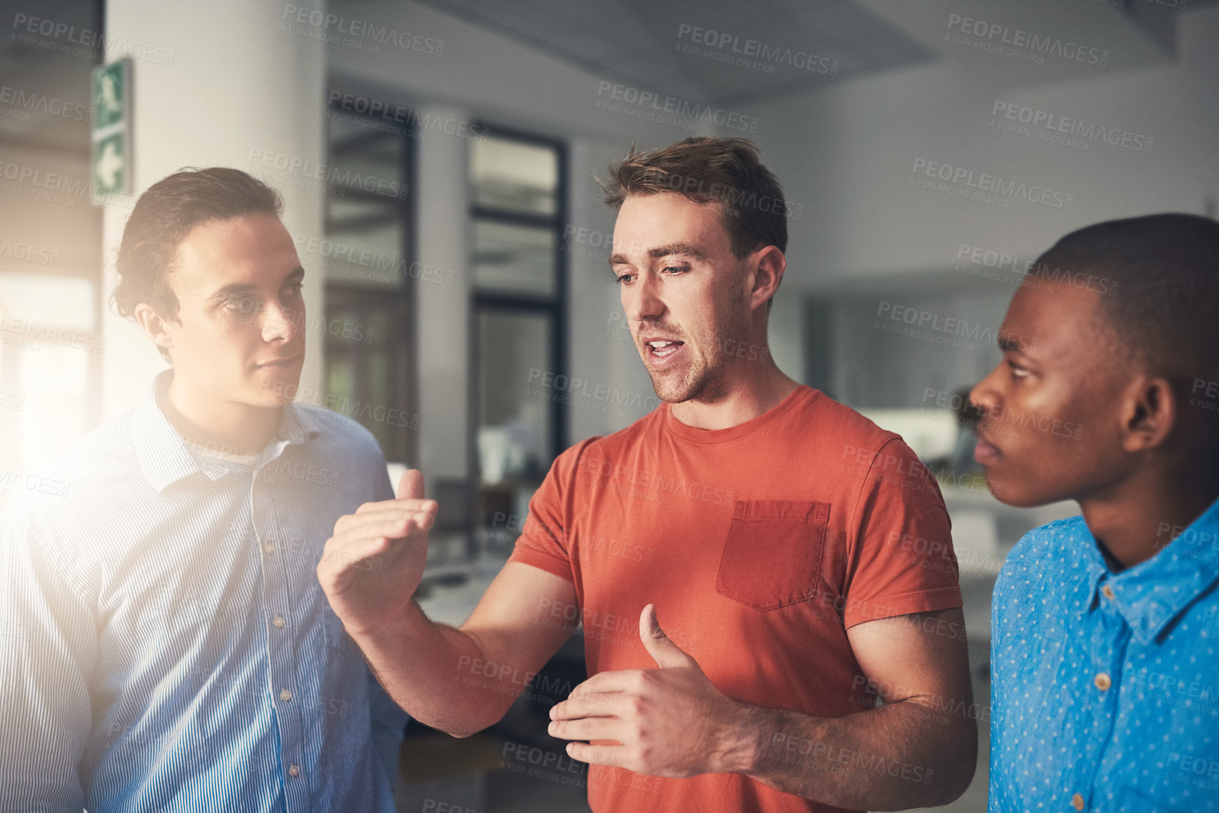 Buy stock photo Shot of three colleagues having a discussion in an office