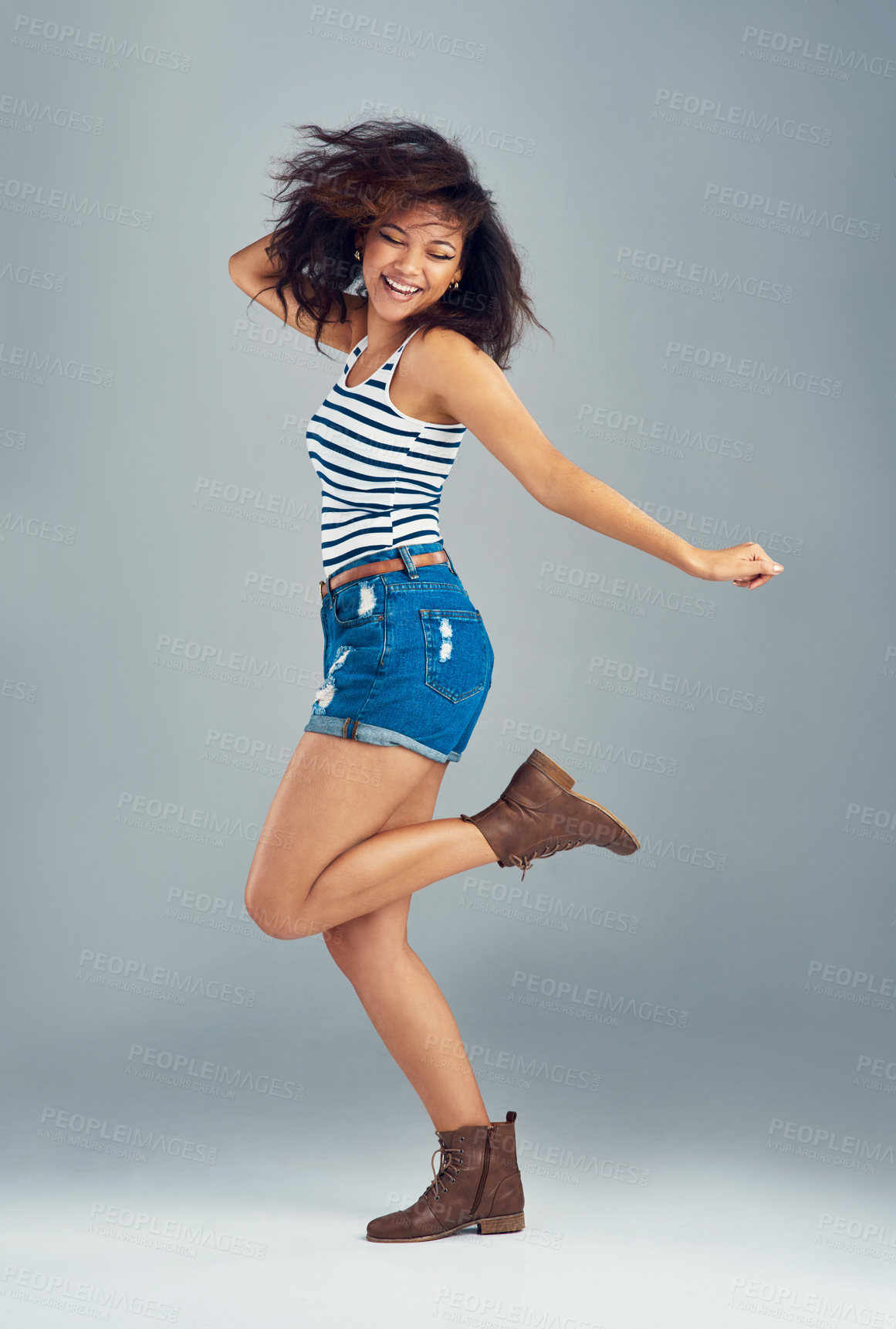 Buy stock photo Shot of a carefree young woman posing against a grey background