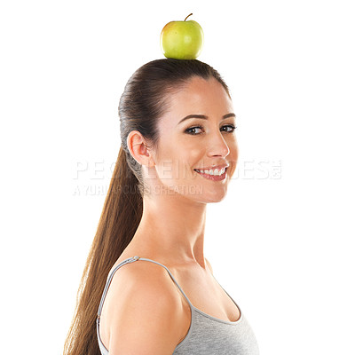 Buy stock photo Portrait, woman and apple with balance on head for health, awareness and wellness for fruit, diet and nutrition. Female person, food and benefits of organic, fiber and vitamin C as snack in studio