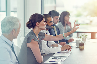 Buy stock photo Cropped shot of a group of businesspeople sitting in a meeting