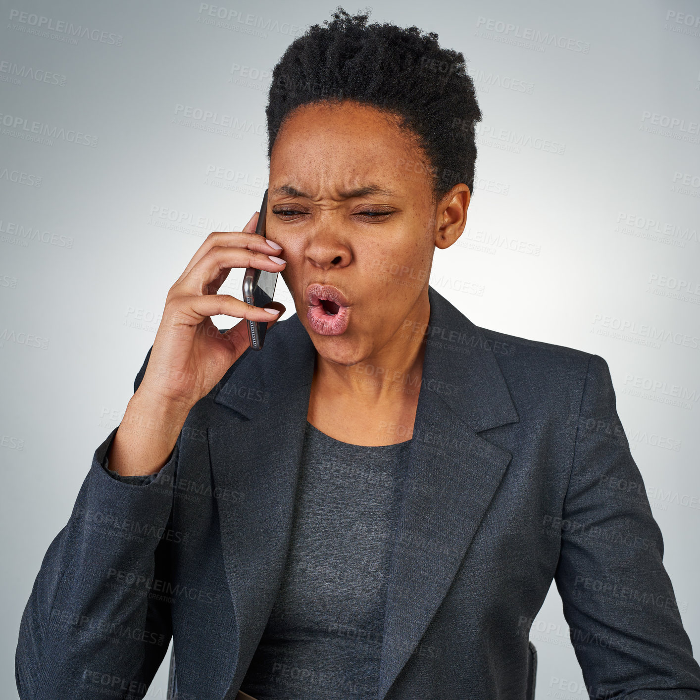 Buy stock photo Cropped shot of an angry businesswoman talking on a cellphone against a grey background