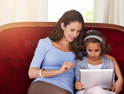 Buy stock photo Cropped shot of a mother and her daughter using a digital tablet