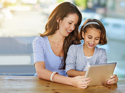 Buy stock photo Cropped shot of a mother and her daughter using a digital tablet