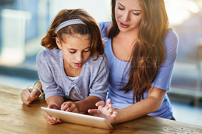 Buy stock photo Elearning, tablet and mom with student in home for online class with homework and education. Smile, love and mother with girl child reading assignment for teaching on digital technology at house.