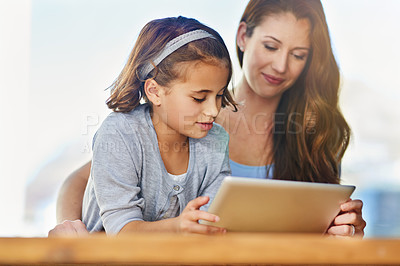 Buy stock photo Cropped shot of a mother and her daughter using a digital tablet