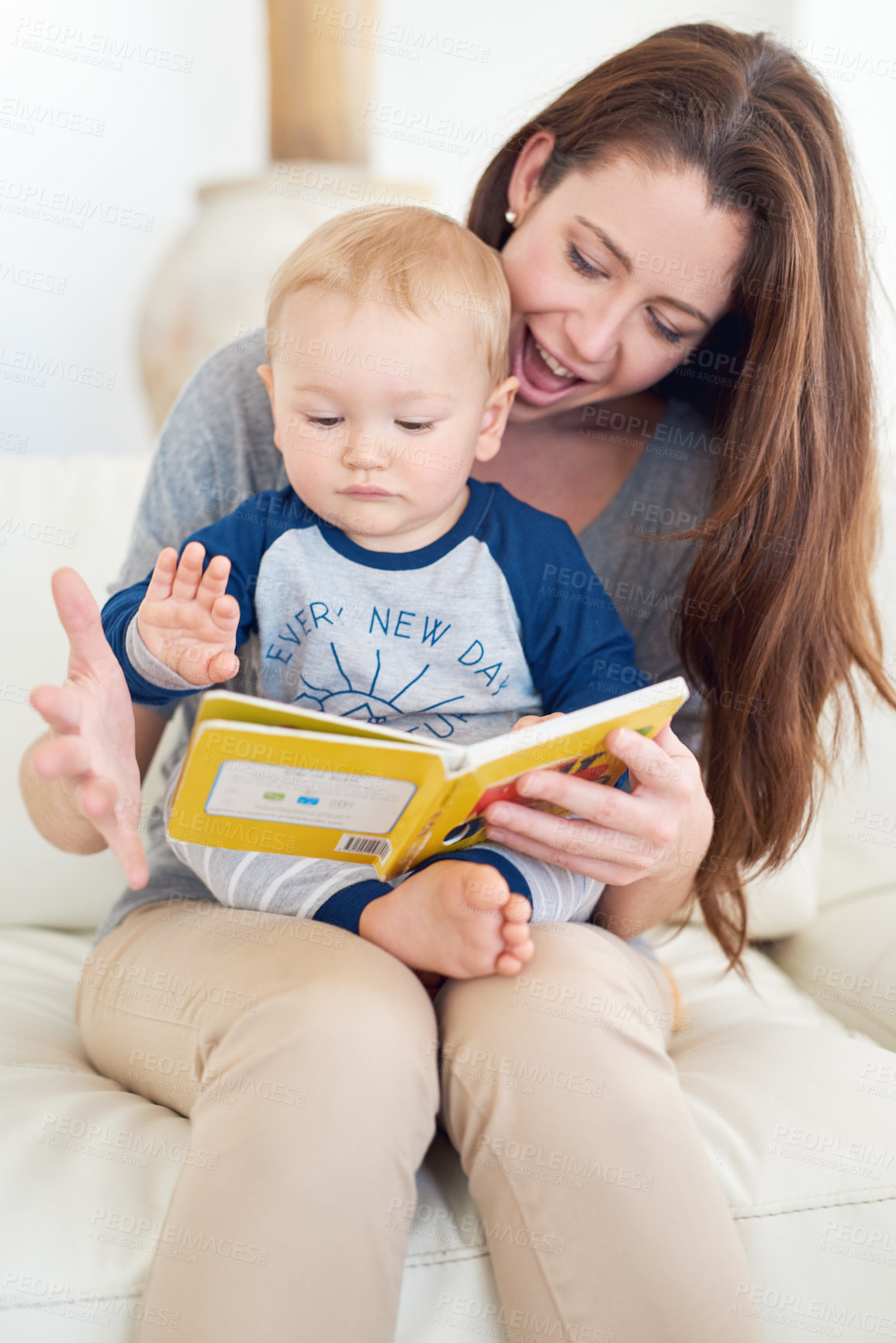 Buy stock photo Cropped shot of a mother reading a book to her baby boy at home