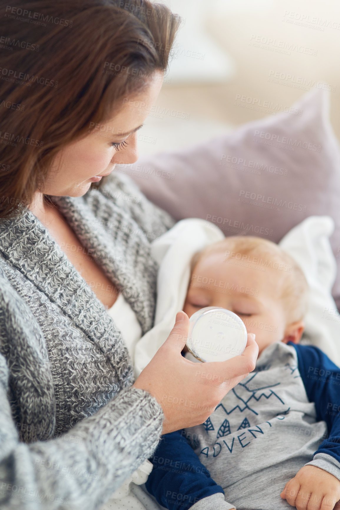 Buy stock photo Cropped shot of a mother feeding her baby boy at home