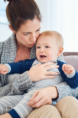 Buy stock photo Cropped shot of a mother trying to console her crying baby boy at home
