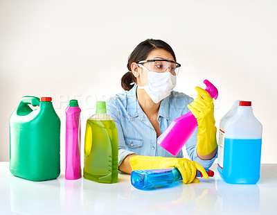 Buy stock photo Detergent bottles, gloves and woman with mask or glasses for protection, safety and cleaning at home. Housekeeping, cleaner or female person with products, liquid container or spray on table for dust