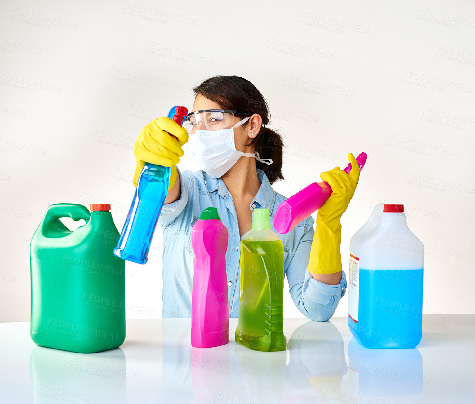 Buy stock photo Detergent bottles, gloves and girl with mask or glasses for protection, safety and cleaning at home. Housekeeping, cleaner or female person with products, liquid container or spray on table for dust