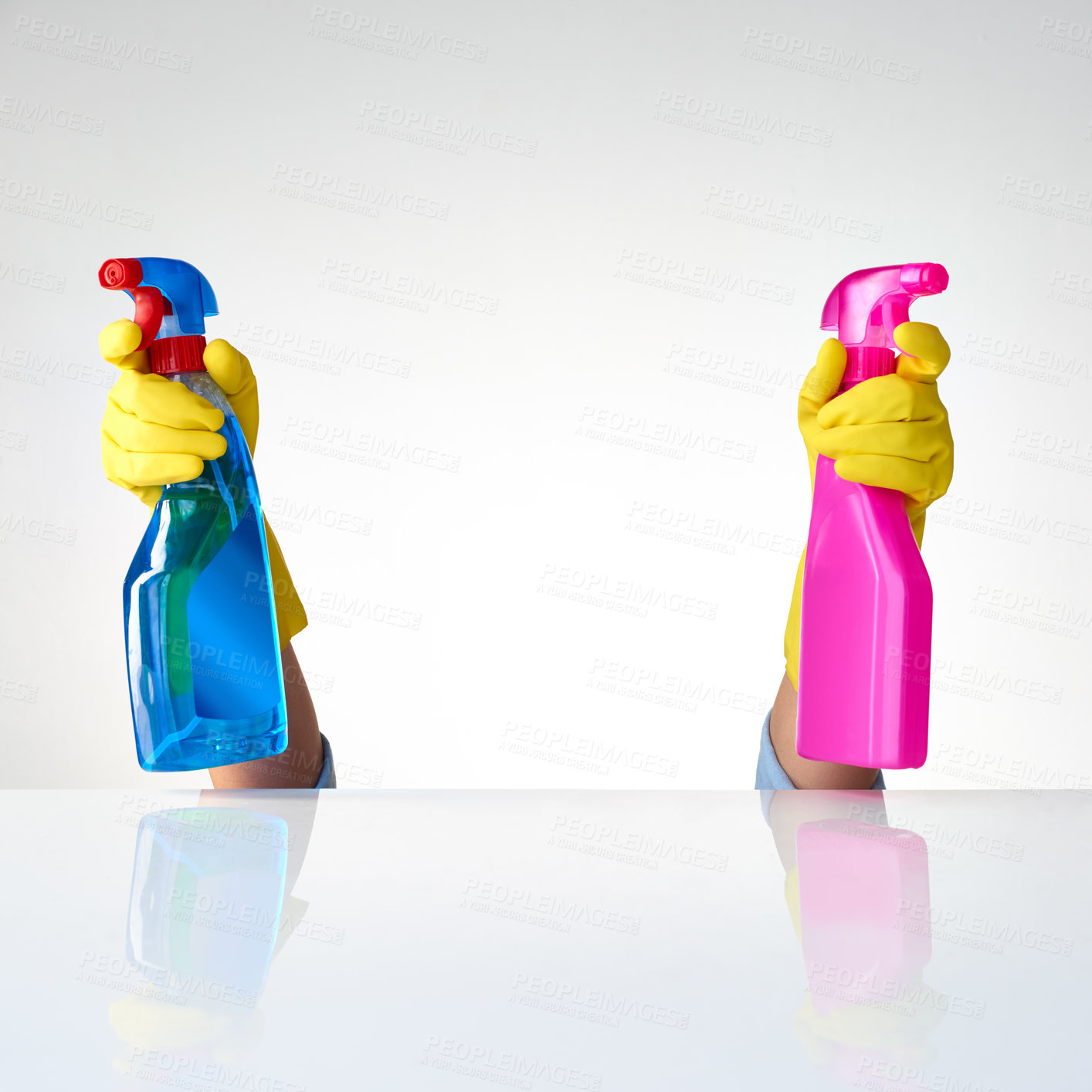Buy stock photo Cropped shot of a person spraying from two bottles of detergents against a grey background