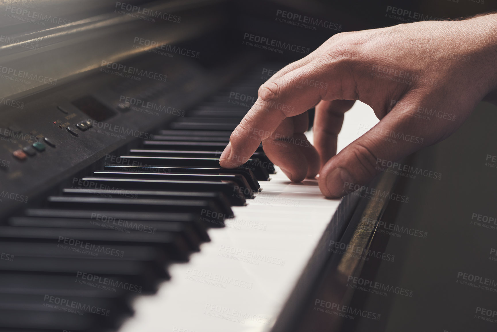 Buy stock photo Cropped shot of a man's hand on a piano keyboard