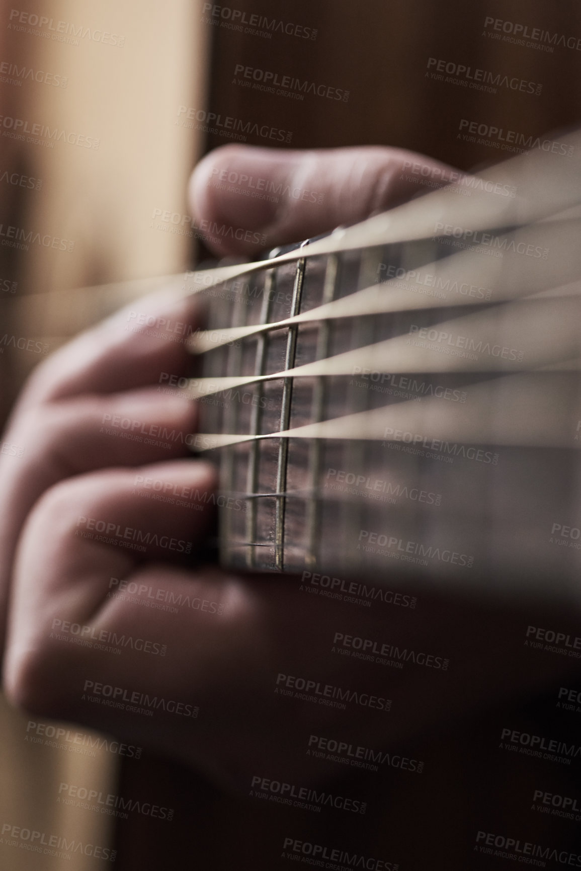 Buy stock photo Cropped shot of an unrecognizable man playing an acoustic guitar at home