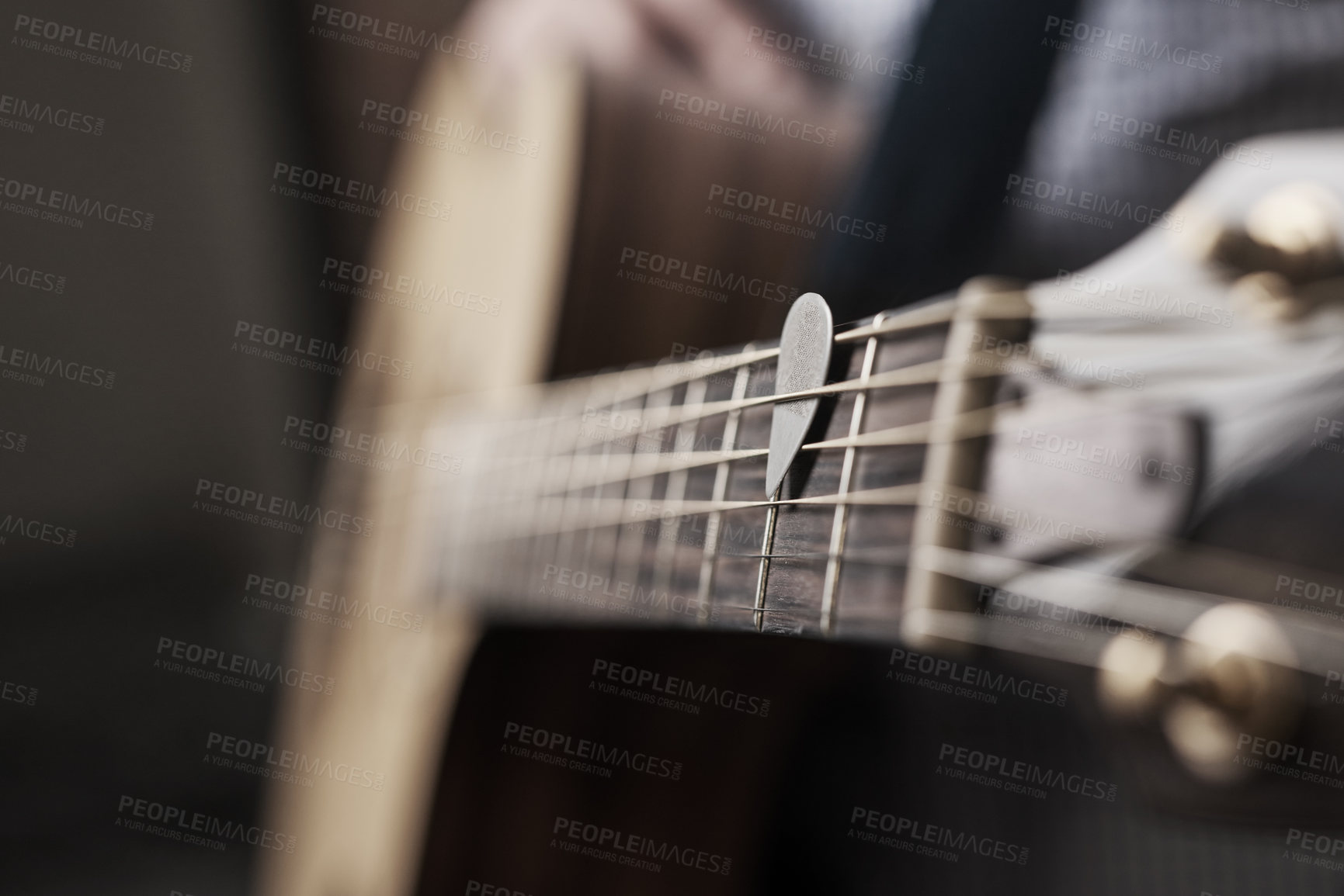 Buy stock photo Cropped shot of an unrecognizable man playing an acoustic guitar at home