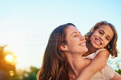 Buy stock photo Cropped shot of a mother giving her daughter a piggyback ride outside